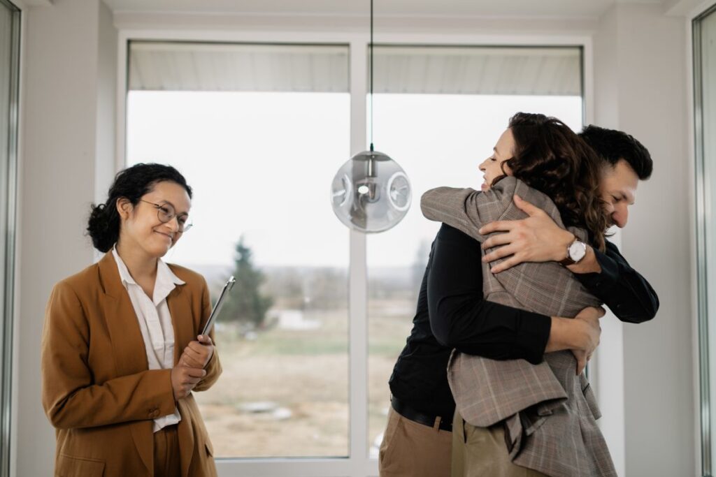 Couple celebrating a completed home purchase with their agent