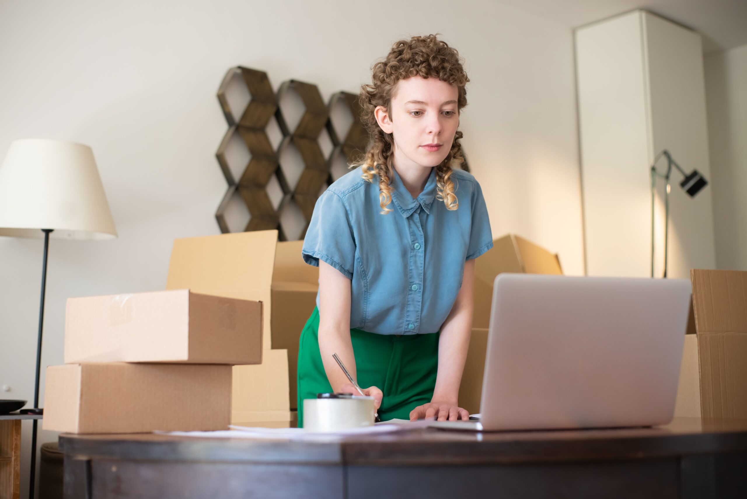Marketplace selling costs reviewed on a laptop beside packed stock